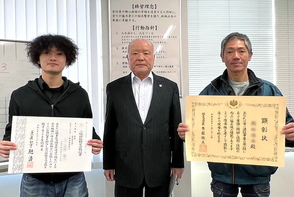 資格認定の賞状を持っているスタッフの写真